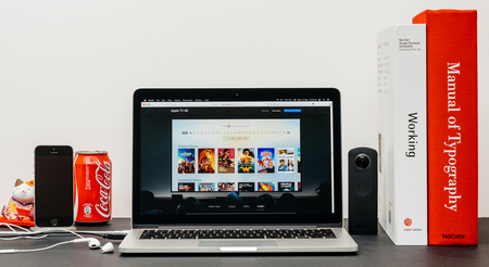PARIS, FRANCE - SEP 13, 2017: Minimalist creative room table with Safari Browser open on MacPook Pro laptop showcasing Apple Computers website with latest Apple TV 4k with search movie and showのeditorial素材