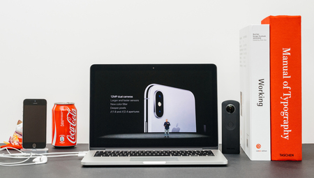 PARIS, FRANCE - SEP 13, 2017: Minimalist creative room and Safari Browser on MacBook Pro laptop showcasing Apple Keynote website with Phil Schiller presenting the new iPhone X 10 AirPower camera photoのeditorial素材