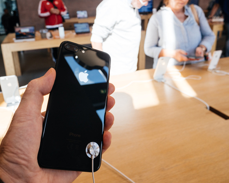 PARIS, FRANCE - SEP 22, 2017: New iPhone 8 and iPhone 8 Plus, as well the updated Apple Watch, Apple TV goes on sale today in Apple Store with customer holding the phone looking at the glass bodyのeditorial素材