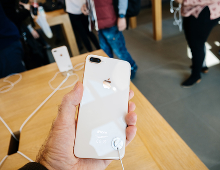 PARIS, FRANCE - SEP 22, 2017: New iPhone 8 and iPhone 8 Plus, as well the updated Apple Watch, Apple TV goes on sale today in Apple Store with customer looking at the glass bodyのeditorial素材