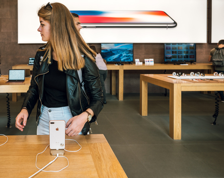 PARIS, FRANCE - SEP 22, 2017: New iPhone 8 and iPhone 8 Plus, as well the updated Apple Watch, Apple TV goes on sale today in Apple Store with young beautiful woman next iphone 8のeditorial素材