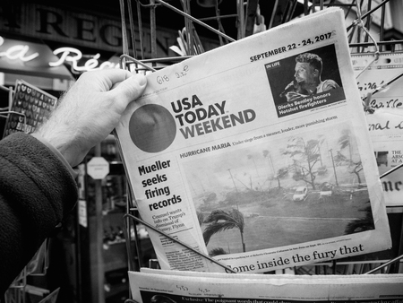 PARIS, FRANCE - SEP 23, 2017: Man buying latest newspaper USA TODAY with Hurricane Maria breaking news and picture of damages wind sea waterのeditorial素材