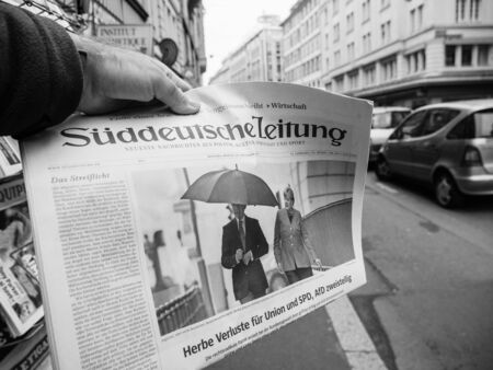 PARIS, FRANCE - SEP 25, 2017: Man buying latest suddeutsche zeitung newspaper with portrait of Angela Merkel with her husband Joachim Sauer after winning the election in Germany for the Chancellor of Germany, the head of the federal governmentのeditorial素材