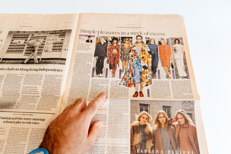 PARIS, FRANCE - SEP 25, 2017: Man reading Financial Times international newspaper about Milan Fashion Week looking at divers styles and looks reading the fashion newsのeditorial素材