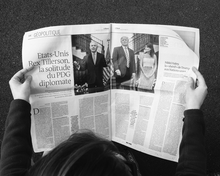 PARIS, FRANCE - SEP 25, 2017: Woman reading international newspaper about Donald Trump, Rex Tillerson and Nikki Halleyのeditorial素材