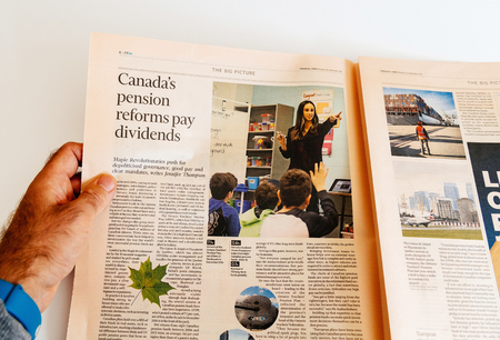 PARIS, FRANCE - SEP 25, 2017: Man reading international Financial Times newspaper article about Canada pensions reform pays dividendsのeditorial素材