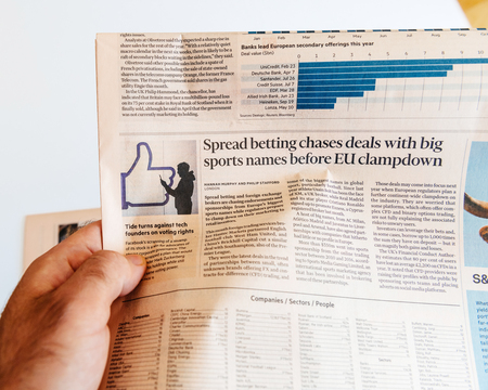 PARIS, FRANCE - SEP 25, 2017: Man reading international newspaper about Mark Zuckerberg Facebook CEO intention to sell 18% of social network stocksのeditorial素材