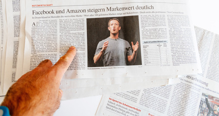 PARIS, FRANCE - SEP 25, 2017: Man reading international newspaper about Mark Zuckerberg Facebook CEO intention to sell 18% of social network stocksのeditorial素材