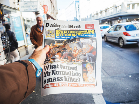 PARIS, FRANCE - OCT 3, 2017: Man buying Daily Dail newspaper with socking title and photo at press kiosk about the 2017 Las Vegas Strip shooting in United States with about 60 fatalities and 527 injuriesのeditorial素材