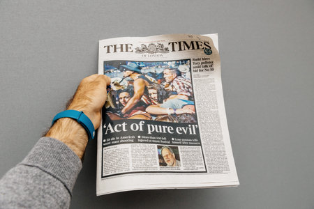 PARIS, FRANCE - OCT 3, 2017: Man holding The Times newspaper cover with socking title Pure Evil and photo after Las Vegas Strip shooting in United Statesのeditorial素材