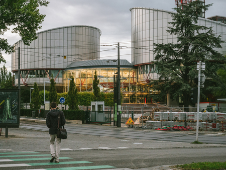 STRASBOURG, FRANCE - SEP 19 2017: European Court of Human Rights in Strasbourg at dusk with man crossing the streetのeditorial素材