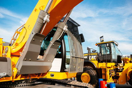 PARIS, FRANCE - SEP 5, 2014: Yellow Liebherr excavator and Cat tractor parked on a street near the...