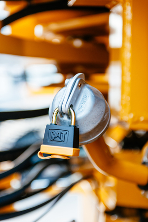 PARIS, FRANCE - CIRCA 2014: Powerful secure metallic lock with the CAT logo on the fuel tank of a excavator, tractor industrial transport at construction siteのeditorial素材