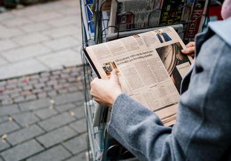 STRASBOURG, FRANCE - OCT 28, 2017: Woman buying FT Weekend newspaper at press kiosk featuring US economy after hurricanesのeditorial素材