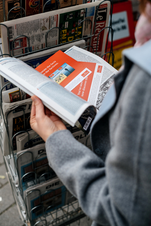 STRASBOURG, FRANCE - OCT 28, 2017: Woman buying reading The Economist business newspaper at press kioskのeditorial素材