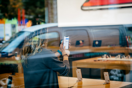 STRASBOURG, FRANCE - NOV 3, 2017: Street view of latest Apple iPhone X in Apple Store with woman using the iMessage Animoji and chat messageのeditorial素材