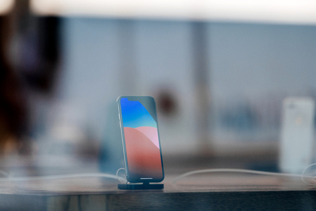 STRASBOURG, FRANCE - NOV 3, 2017: Latest Apple iPhone X goes on sale in Apple Store worldwide - demonstration animation of the phone charging in docking stationのeditorial素材