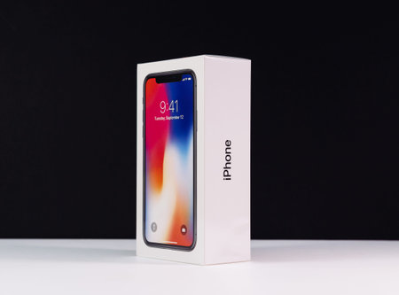 PARIS, FRANCE - NOV 3, 2017: Unboxing unpacking box of the latest Apple iPhone X 10 smartphone against black backgroundのeditorial素材