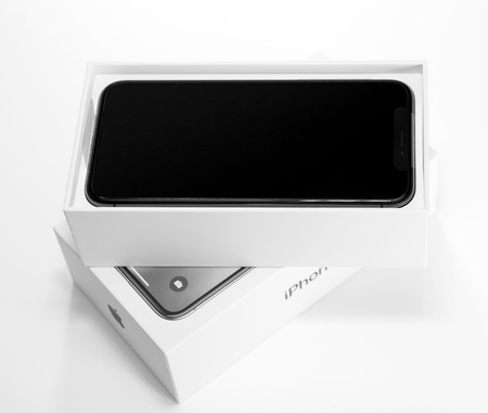 PARIS, FRANCE - NOV 3, 2017: Unboxing unpacking of the latest Apple iPhone X 10 smartphone on white table on the first day of saleのeditorial素材