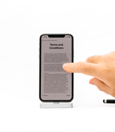 PARIS, FRANCE - NOV 5, 2017: New Apple iPhone X 10 smartphone isolated white background male hand scrolling to read Terms and conditionsのeditorial素材