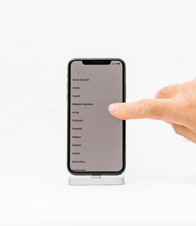 PARIS, FRANCE - NOV 5, 2017: New Apple iPhone X 10 smartphone isolated white background hand scroll to select the language of the phoneのeditorial素材