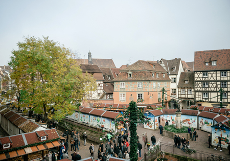 COLMAR, FRANCE - NOV 23, 2015: Aerial view of Colmar Alsace Christmas market with chalets market stall selling gifts, toys, food and people admiringのeditorial素材