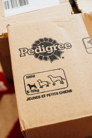 PARIS, FRANCE - SEP 20, 2017: Bone shaped dry pet dog food on a cardboard box with Pedigree logo and doog size schemeのeditorial素材