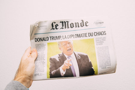 PARIS, FRANCE - NOV 6, 2017: Male hand holding against white background latest Le Monde newspaper...
