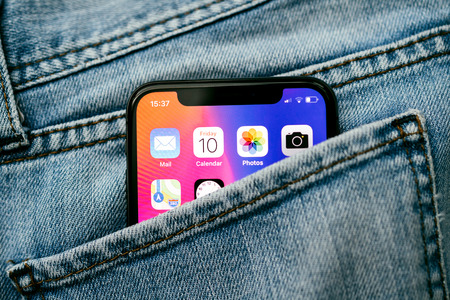 PARIS, FRANCE - NOV 10, 2017: New Apple iPhone X smartphone telephone mobile in pocket of fashion denim jeans pants trousers with home screen appsのeditorial素材