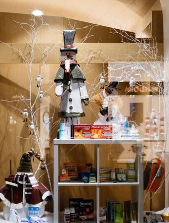 STRASBOURG, FRANCE - NOV 21, 2017: Cough, cold and flu medication and vitamines on display of a winter-theme and Christmas decorated pharmacy store windowのeditorial素材