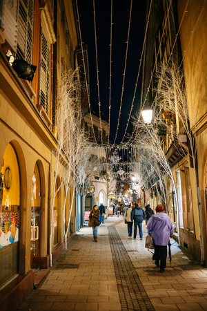 STRASBOURG, FRANCE - NOV 21, 2017: People strolling in the evening on rue des Orfevres with Christmas holiday white decorations in Strasbourg, Alsaceのeditorial素材