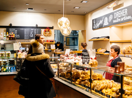STRASBOURG, FRANCE - NOV 21, 2017: Couple buying freshly baked kougelhof cakes and bread in an German artisan bakery Dreher in central Strasbourg, Alsaceのeditorial素材