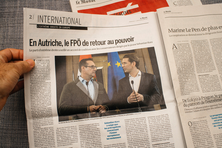 PARIS, FRANCE - DEC 18, 2017: Man reading Le Monde French cover newspaper with headlight and picture about new Chancellor of Austria Sebastian Kurz and Heinz-Christian Strache Austria's vice chancellorのeditorial素材