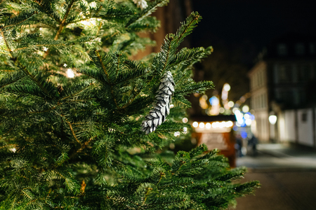 Fir tree with decorated toy cone with urban city in the background during winter holidaysの写真素材