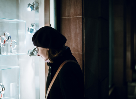 Woman shopping and dreaming for jewelries in France during Christmas Market  in front of the window store of a generic luxury storefront facadeの写真素材