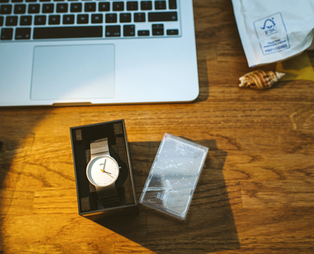 PARIS, FRANCE - DEC 5, 2017: unboxing new Braun German watch clock on work table with Apple MacBook retina laptop workingのeditorial素材