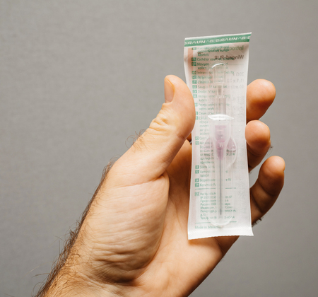 PARIS, FRANCE - NOV 22, 2017: Male Doctor holding  in hand Safety Catheter IV made by Braun Melsungen AG front view with plastic filmのeditorial素材