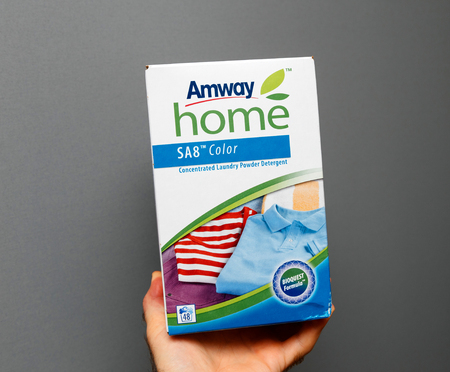 PARIS, FRANCE - JAN 23, 2018: Man holding against gray background a new box of Amway Home Color Concentrated Laundry Powder Detergent SA8のeditorial素材