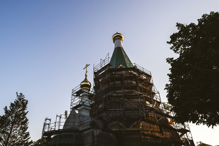 Scaffolding on the Russian Orthodox Church of All Saints facade with divine susnetの写真素材
