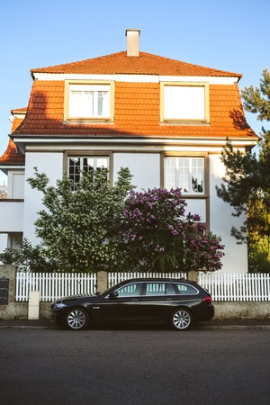 PARIS, FRANCE - APR 21, 2017: New black BMW 5 Series wagon on the street of Paris with lilac flower and beautiful house in the backgroundのeditorial素材
