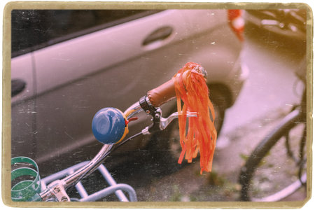 Bicycle handlebar steering with vintage blue horn and decoration parked in city with sun flare and vintage frameの写真素材
