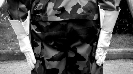 Rear view of military solider in camouflage and white glovesの写真素材