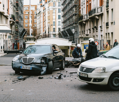 PARIS, FRANCE - JAN 30, 2018: Front view of car accident on Paris street between luxury limousine Lancia Thesis and scooter moped transporting medical transfusion blood - rue de Courcellesのeditorial素材