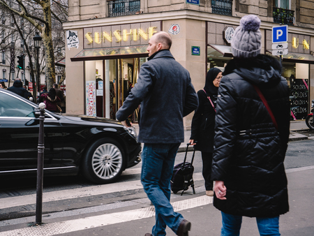 PARIS, FRANCE - JAN 30, 2018: Confident french male and female crossing street in front of Mercedes -Benz luxury limousine in Paris, on the Rue St Vincent de Paulのeditorial素材