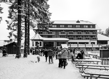 SEEBACH MUMMELSEE, GERMANY - FEB 18, 2018: Winter day with snow with people walking toward the restaurant cafe hotel near the frozen Mummelsee lakeのeditorial素材