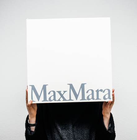PARIS, FRANCE - FEB 16, 2018: Smiling elegant fashionista woman holding Max Mara Italian cardboard fashion  parcel box being happy with her purchase of the new coatのeditorial素材