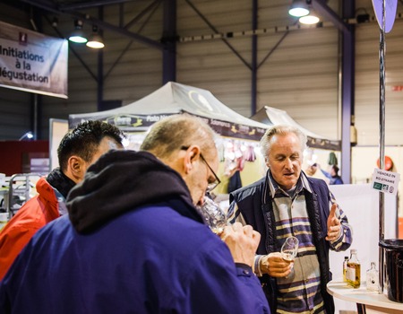 STRASBOURG, FRANCE - FEB 19, 2018: Sommelier selling explaining to customers tasting buying French wine at Vignerons independant English: Independent winemakers of France wine fair in Strasbourgのeditorial素材