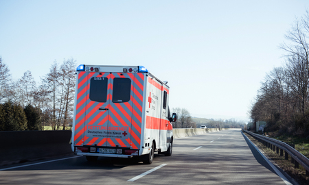 ACHERN GERMANY - FEB 18, 2018: Fast driving in front Deutsches Rotes Kreuz ambulance on German rural roadのeditorial素材