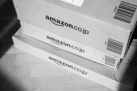 PARIS, FRANCE - FEB 21, 2018: Black and white image of Amazon Prime Japan boxes stack on wooden bacgroundのeditorial素材