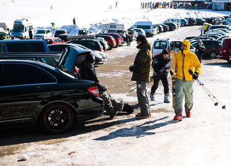 SEEBACH MUMMELSEE, FEB 25, 2018: Snowboarders resting after game seated on a Mercedes-Benz fast car parked in large parkingのeditorial素材